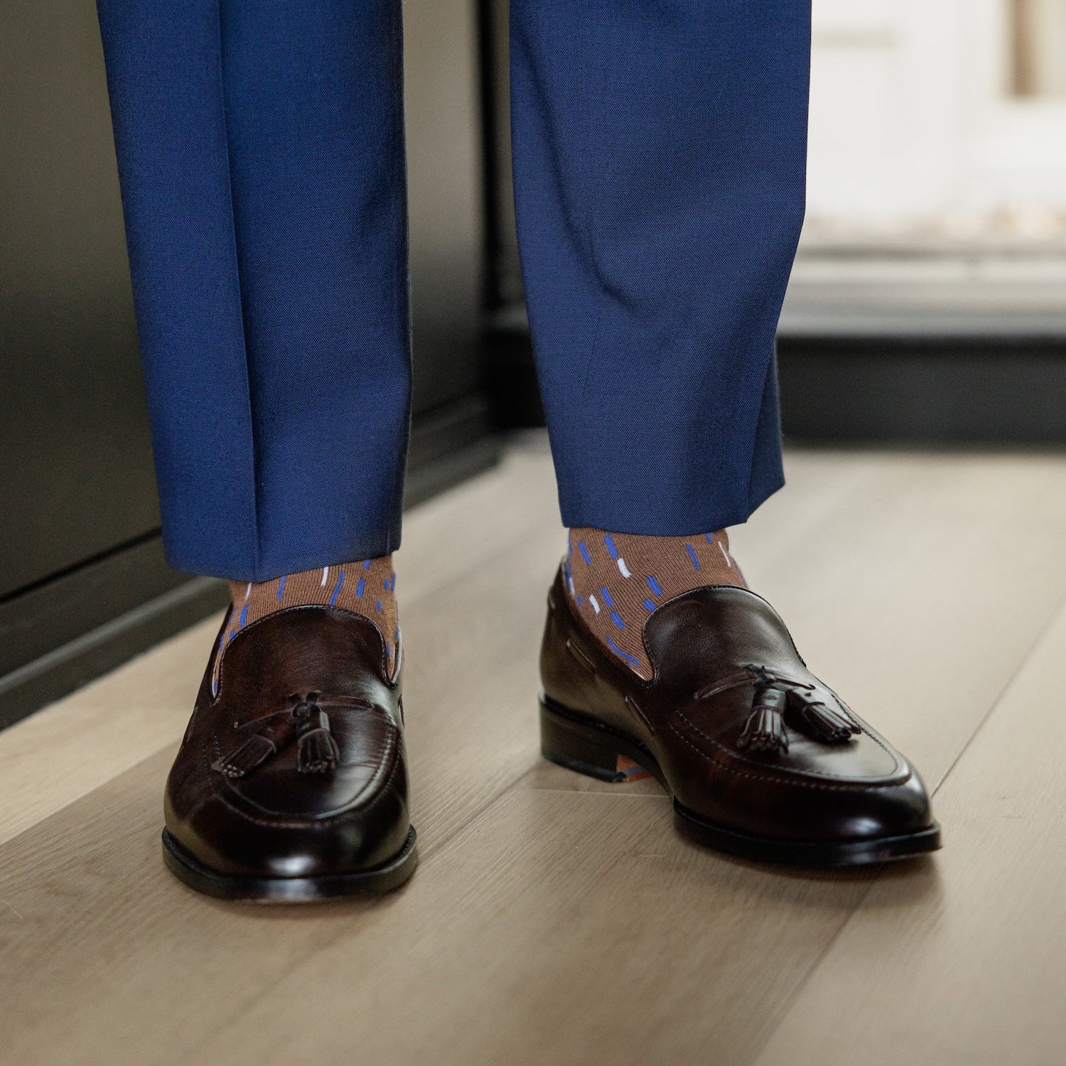 A mocha mousse brown men's dress sock with a blue and white dashed line pattern