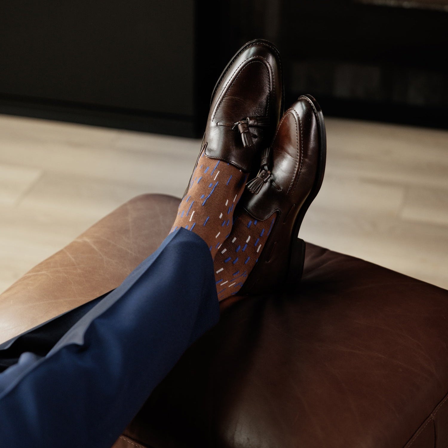 A mocha mousse brown men's dress sock with a blue and white dashed line pattern