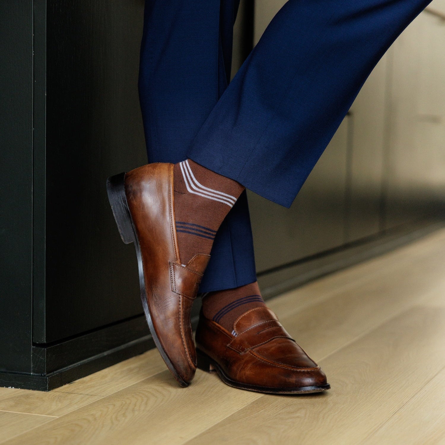 A pecan brown men's dress sock with navy and white stripes