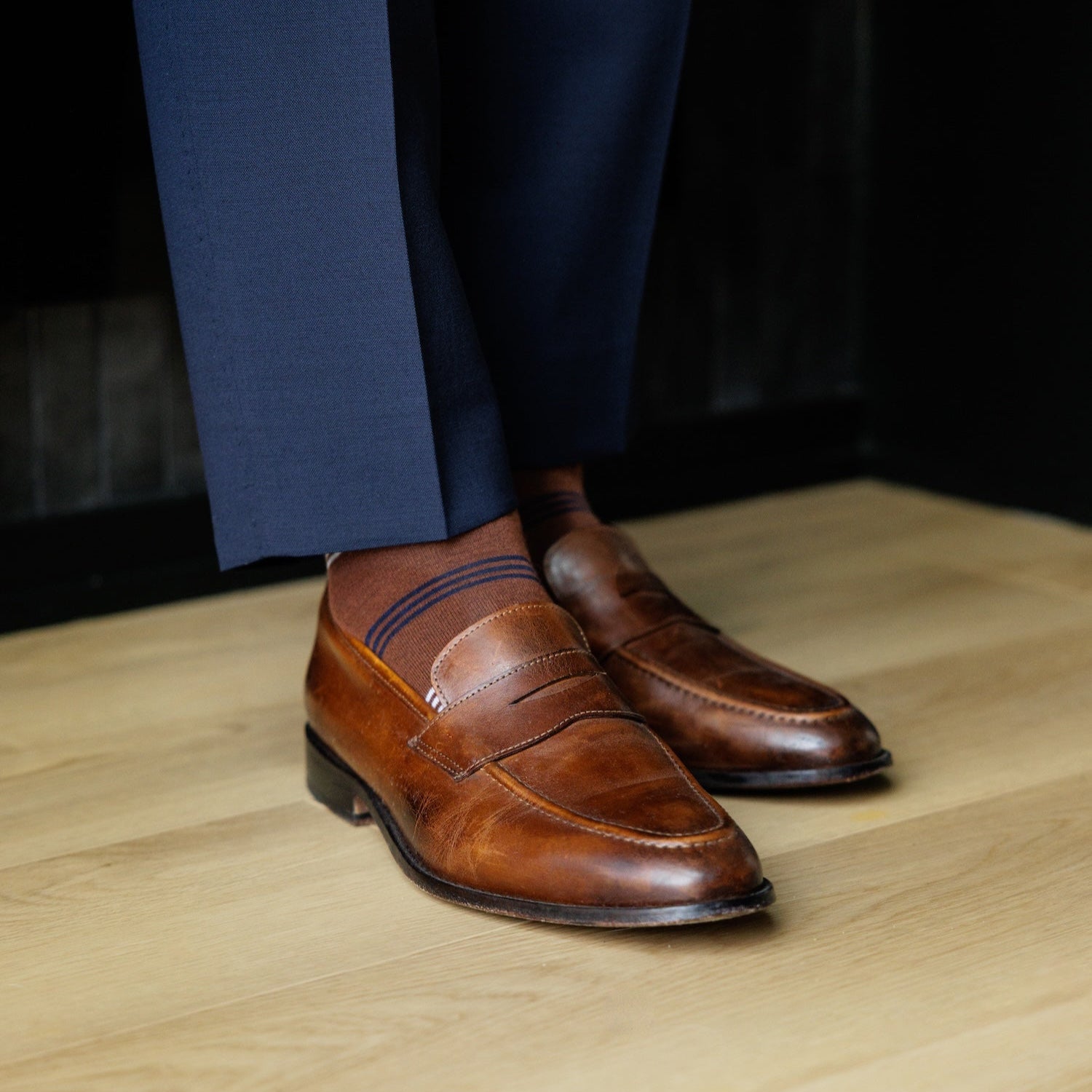 A pecan brown men's dress sock with navy and white stripes