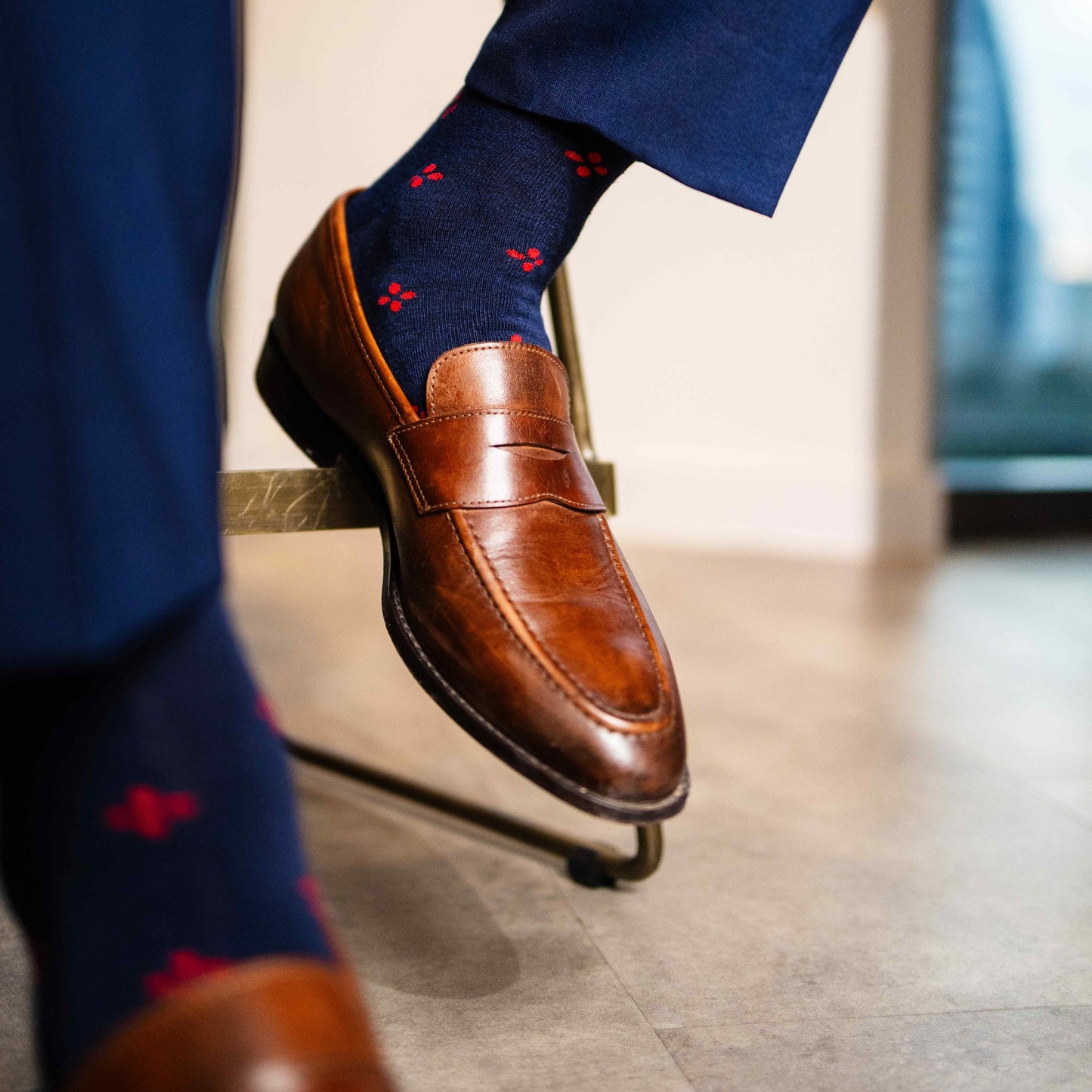 Navy blue men's sock with a cherry red flower pattern