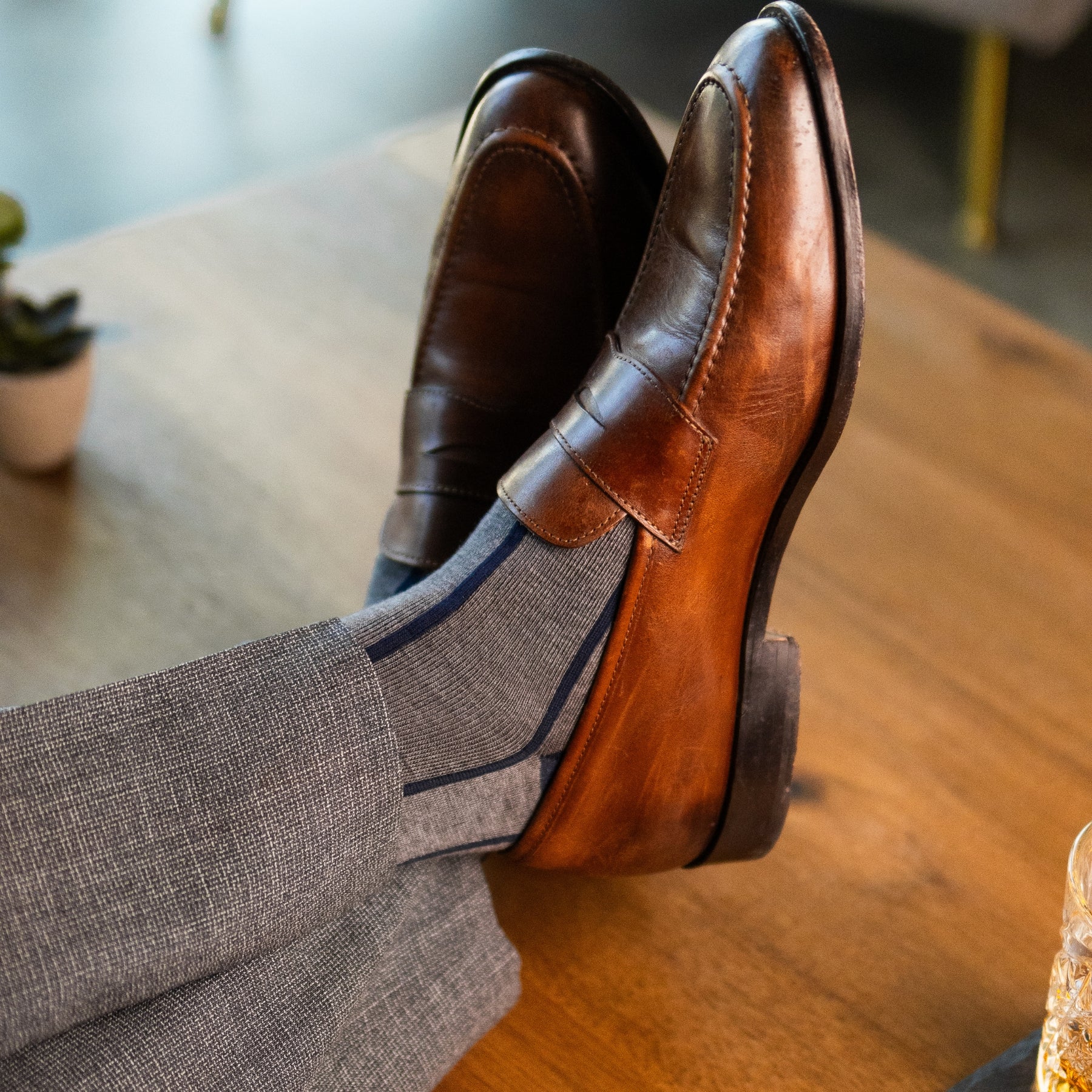 A grey men's dress sock with a navy blue vertical stripe pattern