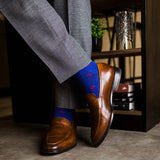 guy in grey slacks wearing royal blue men's dress socks with a red floral flower pattern