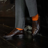 Man wearing orange, solid, tangerine ribbed men's dress socks.