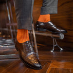 Man wearing orange, solid, tangerine ribbed men's dress socks.