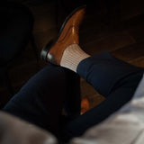 Man wearing oatmeal, solid, mocha ribbed men's dress socks.