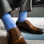 Man wearing steel blue men's dress socks and brown shoes.