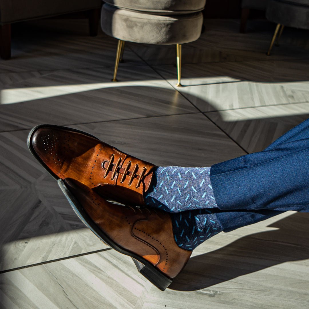 A dark blue men's dress sock with a light blue sprinkle pattern