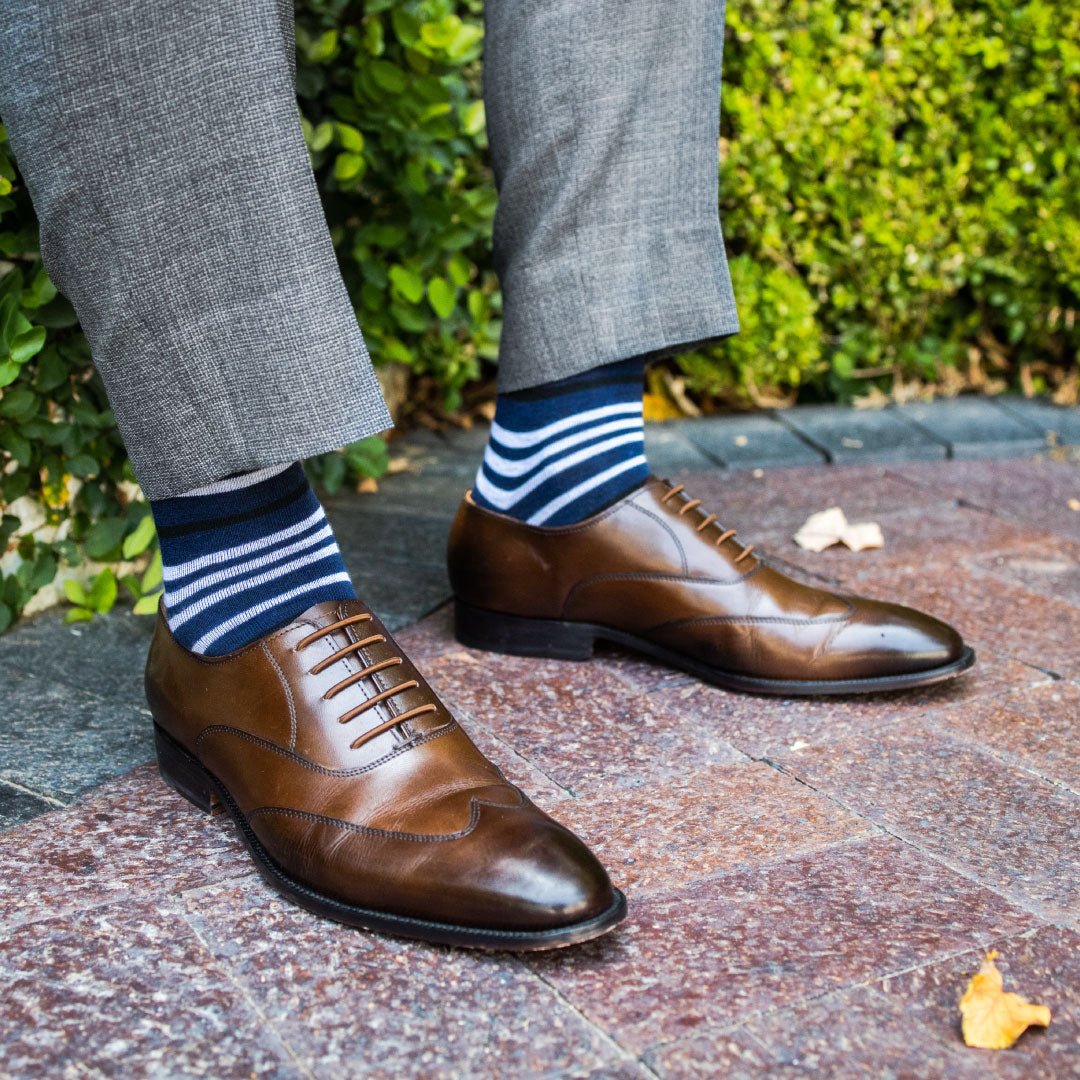 man wearing dark blue sock with white and black stripe pattern
