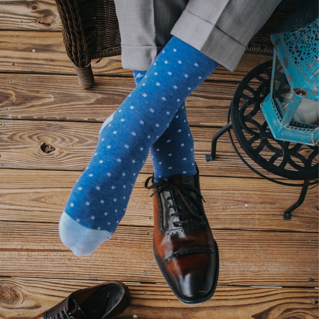 Man sitting wearing heathered blue and ocean blue micro-square socks