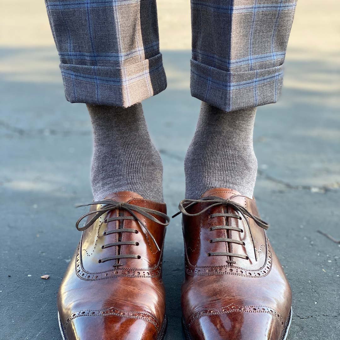 Man wearing steel gray men's dress socks, and brown shoes.