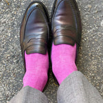 Man wearing fuchsia men's dress socks and brown shoes.