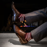 man wearing deep red sock with white and black stripes