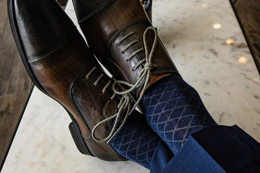 Brown leather dress shoes paired with blue patterned dress socks.