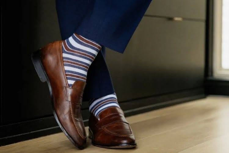 Striped dress socks styled with brown loafers.
