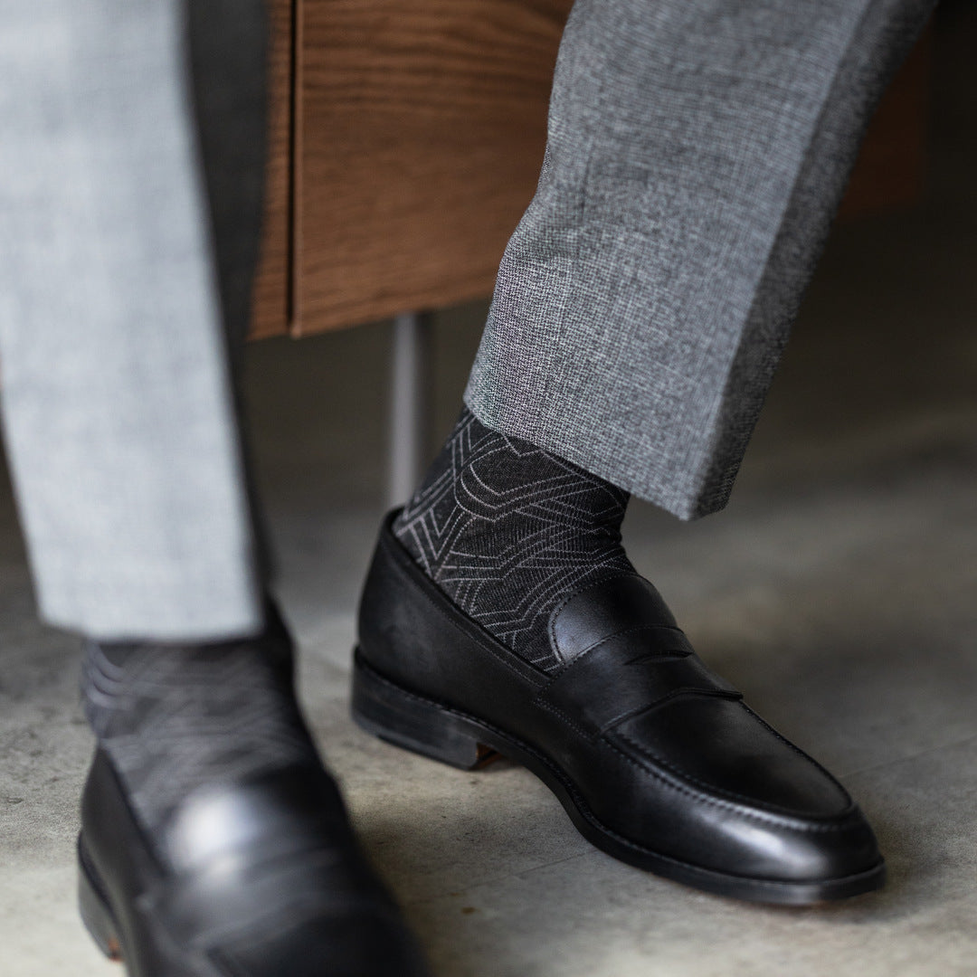 The Black & Silver Square-Grid dress sock with a loafer in a raised-foot close-up