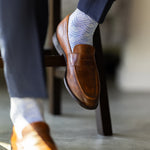 The Blue-Grey & Cobalt Square-Grid dress sock with a loafer in a raised-foot close-up