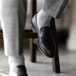 The Pearl Grey Square-Grid dress sock with a loafer in a raised-foot close-up