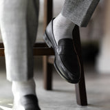 The Pearl Grey Square-Grid dress sock with a loafer in a raised-foot close-up