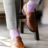 The Lavender & Plum Square-Grid dress sock with tailored trousers and a loafer in a seated foreground view