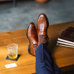 Brown Gemstones dress socks with navy trousers and loafers beside a glass