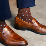 Close-up of a brown Gemstones dress sock above a brown penny loafer