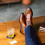 Close-up of brown Gemstones dress socks with navy trousers and penny loafers