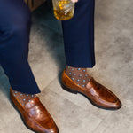 Brown Gemstones dress socks with navy trousers and brown penny loafers viewed from above