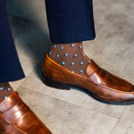 Close-up of a brown Gemstones dress sock with navy trousers and a brown loafer