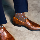 Close-up of a brown Gemstones dress sock with navy trousers and a brown loafer