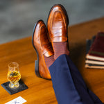 Mocha patterned dress socks with navy trousers and brown penny loafers