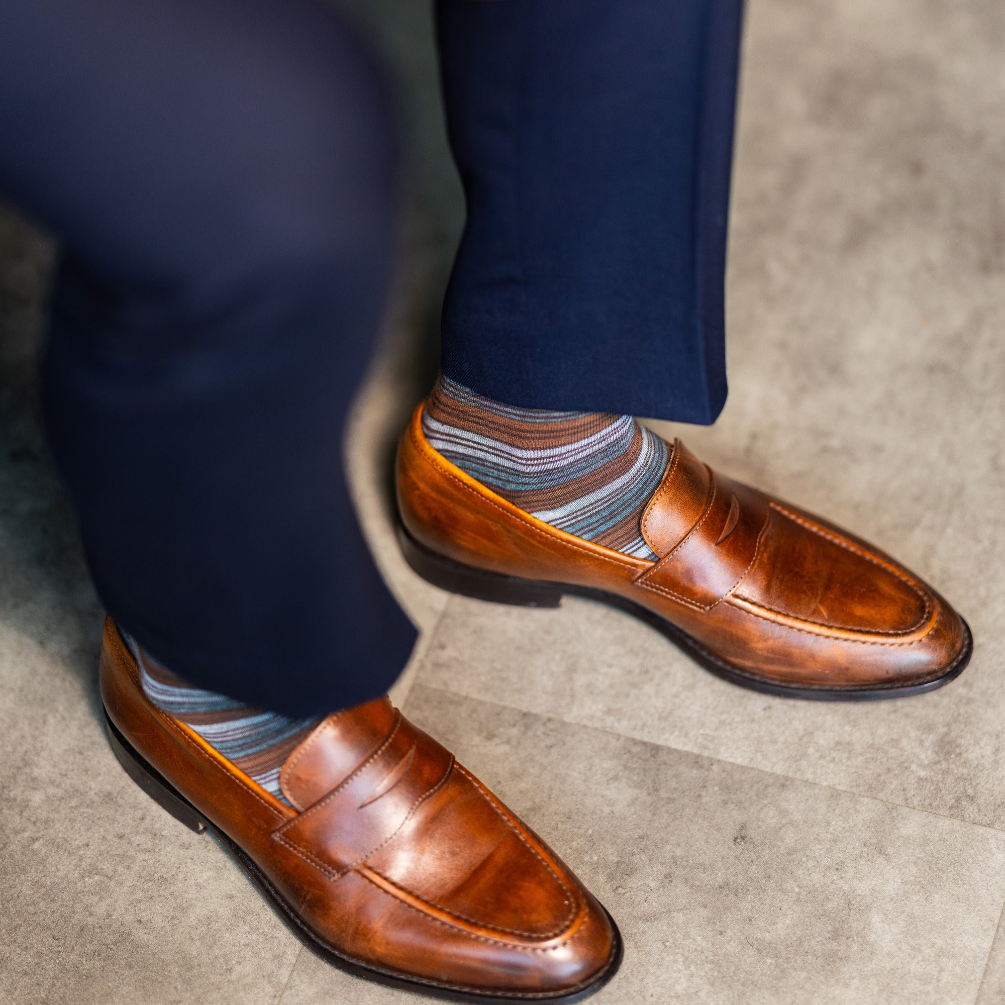 Multi-stripe dress socks with navy trousers and brown penny loafers
