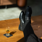 The Black Nested Diamonds men's dress sock — black sock with grey nested diamonds styled with black trousers