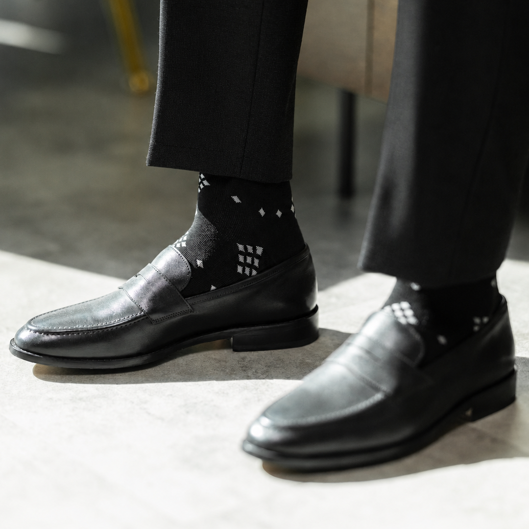The Black Nested Diamonds men's dress sock — black sock with grey nested diamonds styled with black trousers