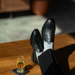The Grey Nested Diamonds men's dress sock — grey sock with black nested diamonds styled with black trousers