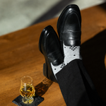 The Grey Nested Diamonds men's dress sock — grey sock with black nested diamonds styled with black trousers