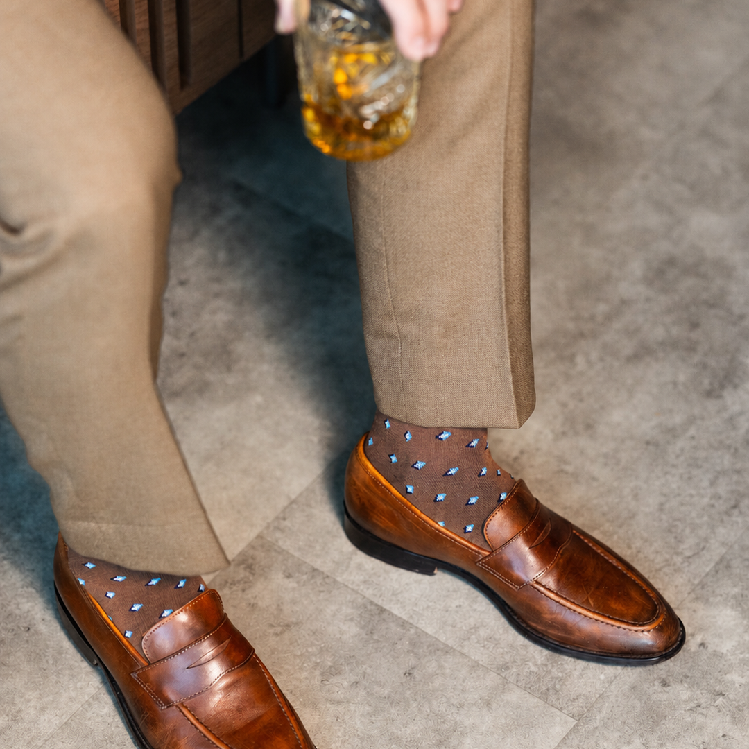 The Mocha Gemstones men's dress sock — mocha sock with navy, white & powder blue gemstones styled with tan trousers