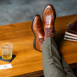 The Pecan Gemstones men's dress sock — pecan brown sock with navy, white & powder blue gemstones styled with olive trousers