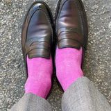 Man wearing fuchsia men's dress socks and brown shoes.