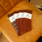Close-up of the five Fall Brown Bundle dress socks on a leather chair