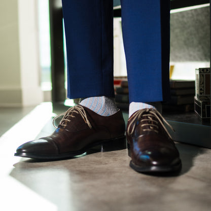 A Light Grey Sock with an Arctic Blue Ribbed Pattern