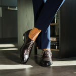 A mandarin orange men's dress sock with a navy ribbed pattern