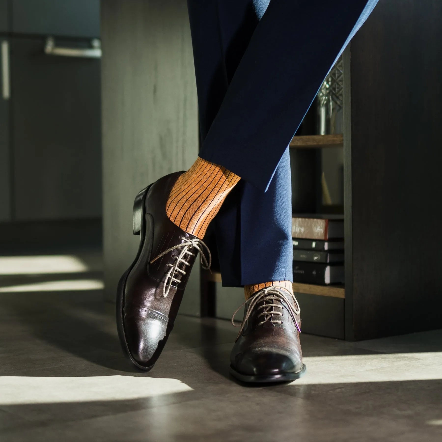 A mandarin orange men's dress sock with a navy ribbed pattern