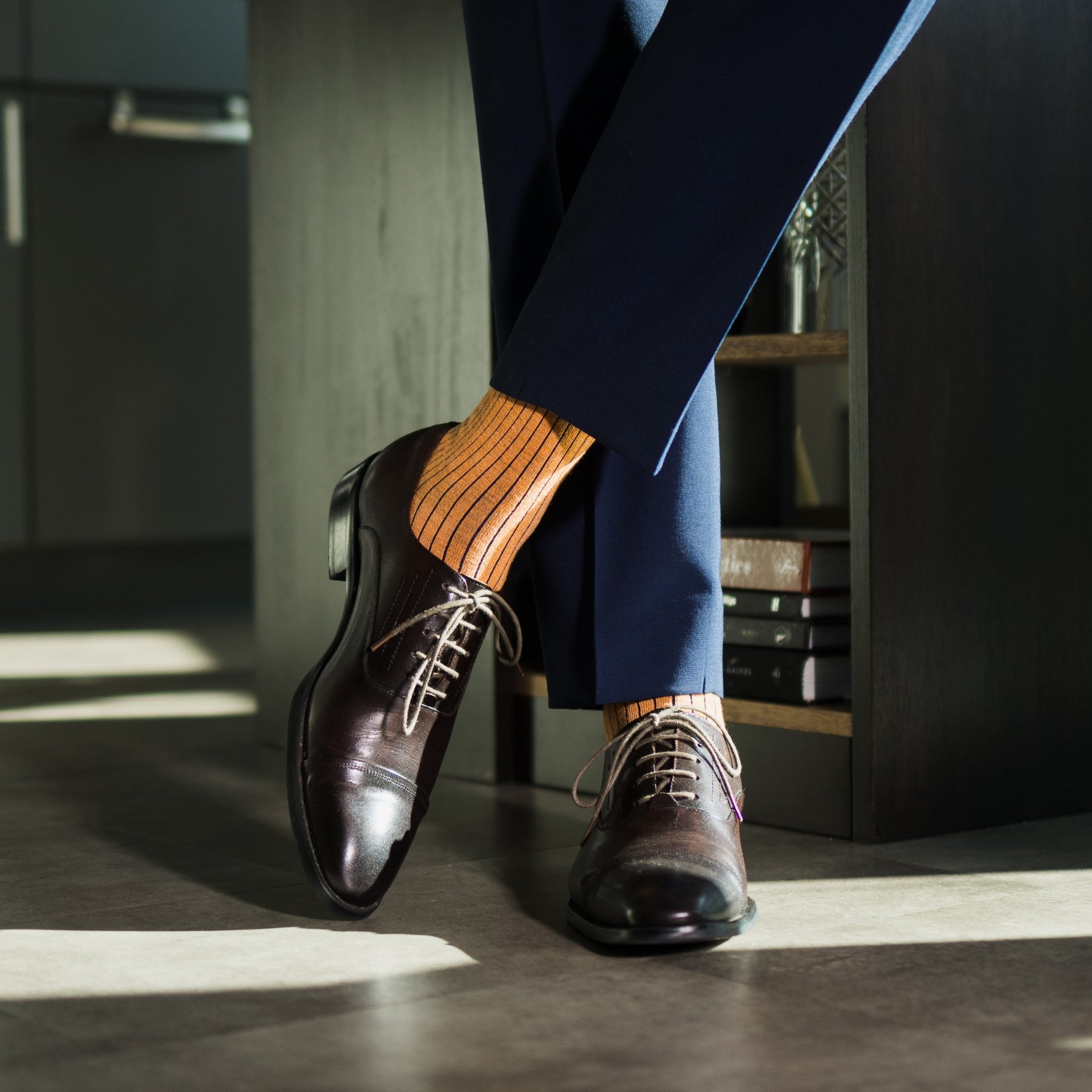 A mandarin orange men's dress sock with a navy ribbed pattern