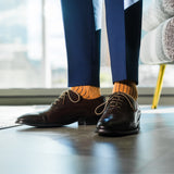 A mandarin orange men's dress sock with a navy ribbed pattern