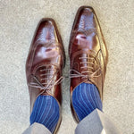 Man wearing midnight blue, solid, ribbed men's dress socks with brown shoes.