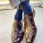 Man wearing midnight blue, solid, ribbed men's dress socks with brown shoes.