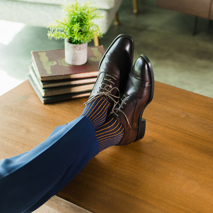 A navy men's dress sock with an orange ribbed pattern