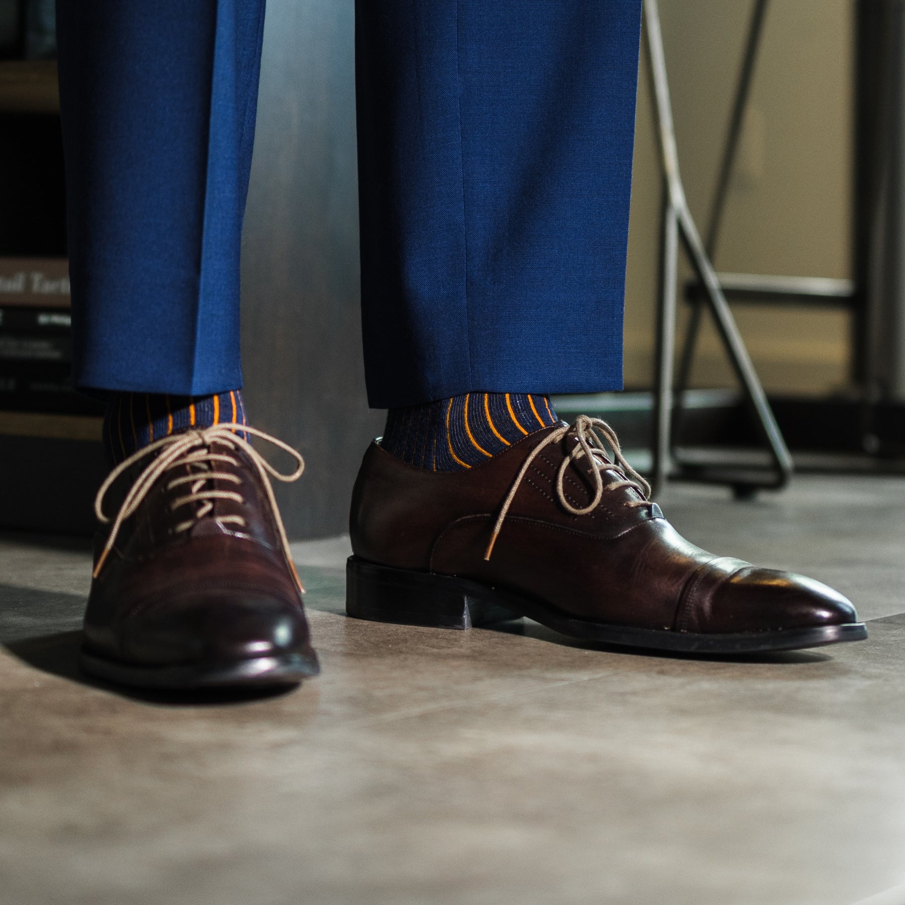 A navy men's dress sock with an orange ribbed pattern