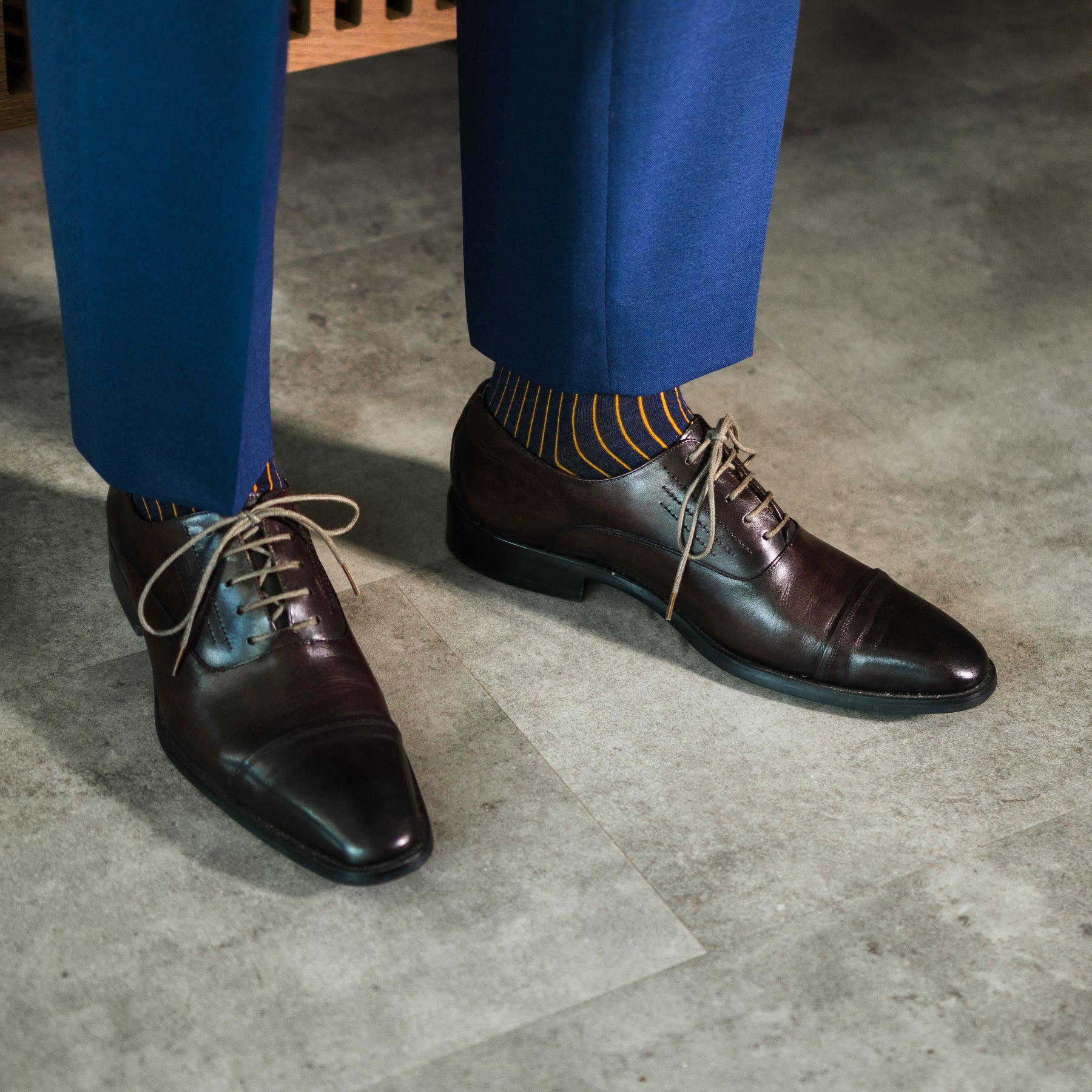 A navy men's dress sock with an orange ribbed pattern